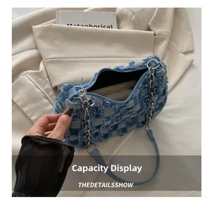 Interior capacity display of checkered denim bag with silver chain and fringe details