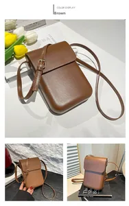 Detailed view of brown leather mobile phone bag with adjustable golden buckle strap