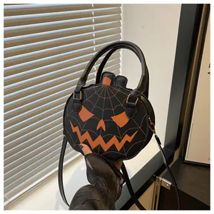 Detail view of Halloween pumpkin bag with orange spider web and scary face pattern