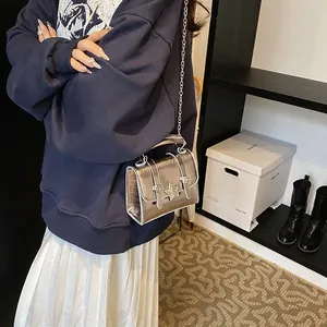 Mini borsa a tracolla argento lucido con stella e tracolla a catena indossata da modella