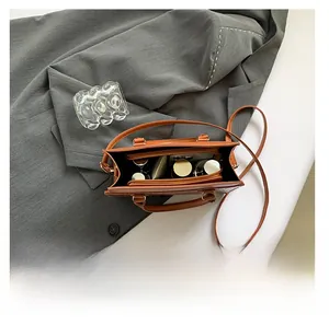 Detail view of the brown woven tote bag interior showing capacity for phone and cosmetics