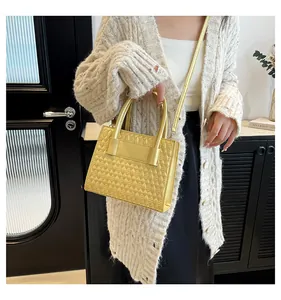 Detail der leuchtend gelben gesteppten Handtasche mit Rautenmuster und Metallic-Finish