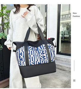 Detalle de bolso grande con estampados de letras y tejido empalmado impermeable