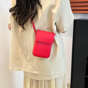 Minimalistische rote Leder-Handytasche zum Umhängen, getragen von einem Model von hinten