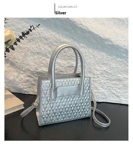 Details einer silbernen Stepphandtasche mit Blattmuster und eleganten Beschlägen