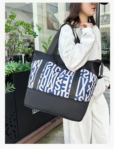 Primer plano de un gran bolso tote con estampado de letras y asas anchas negras