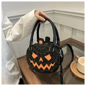 Detail of Halloween pumpkin round crossbody bag with spider web stitching and orange face