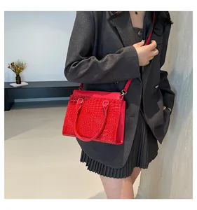 Detail of red crocodile pattern tote bag with gold hardware and stylish top handles