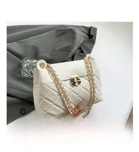 Détail du matelassage blanc en losange et du fermoir doré sur le sac à bandoulière chic