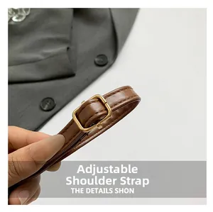 Close-up of adjustable brown leather shoulder strap with gold buckle and fine stitching
