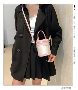Sac seau rose en cuir et dentelle avec bandoulière porté par un mannequin en noir