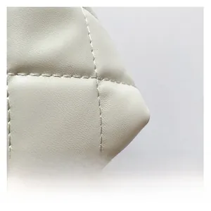Gros plan sur la texture du cuir matelassé avec surpiqûres classiques en losanges