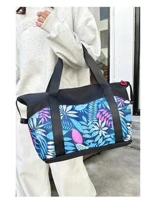 Detalle del bolso de viaje con estampado de hojas y compartimento para zapatos independiente