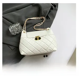 Détail de la texture matelassée et du fermoir doré sur un sac beige à chaîne