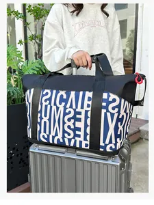 Detalle macro del bolso de viaje grande con estampado geométrico y asa para maleta