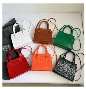 Flat lay of crocodile pattern tote bags in six vibrant colors with gold hardware