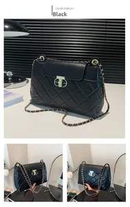 Détail du sac à bandoulière matelassé noir avec chaîne dorée et fermoir en métal en T