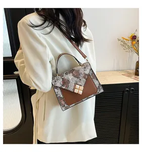 Detail view of snakeskin pattern leather crossbody bag with golden square metal buckle