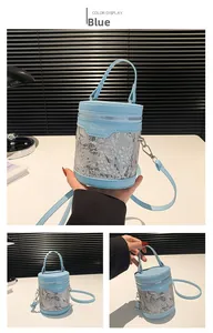 Détail du sac seau bleu clair avec revêtement en dentelle florale et bandoulière amovible