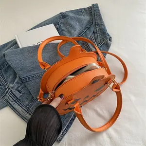 Round pumpkin shaped orange crossbody bag with Halloween face and adjustable strap