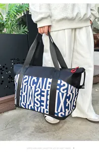 Detalle de la bolsa de viaje grande tipo patchwork con cremallera roja y letras impresas