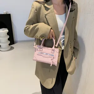 Minimalist light pink crossbody handbag with decorative silver zipper and fringe tassel