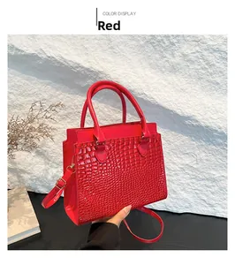 Close-up of red crocodile pattern tote bag with gold hardware and circular handles