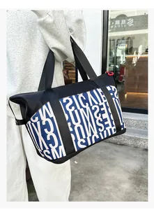 Primer plano del estampado de letras azules y cremallera roja del bolso de viaje