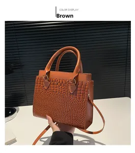 Detailed close-up of brown croc-embossed tote bag with elegant gold hardware and handle