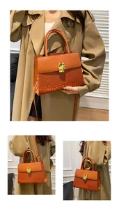 Détails de la texture crocodile et fermoir doré sur le sac à main marron caramel