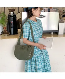 Olive green corduroy crescent crossbody bag showing spacious capacity on model