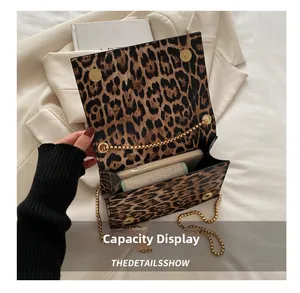 Capacité intérieure du mini sac léopard montrant un smartphone et un petit portefeuille