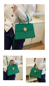Détail du sac à main vert émeraude avec cuir embossé crocodile et boucle dorée chic