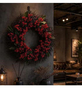 Detailed view of festive Christmas wreath with red berries and green leaves on grey wall