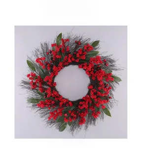 Close-up of artificial Christmas wreath with red berries, green leaves and dry branches