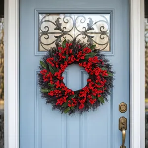 Christmas wreath with red berries and green leaves on a vintage blue door background