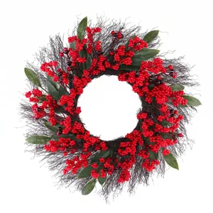 Christmas wreath with red berries and green leaves on dark branch base for holiday decor