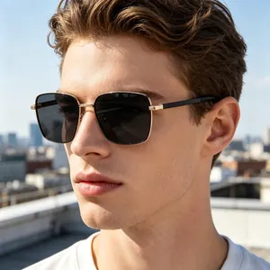 Detail of square gold metal frame sunglasses with dark lenses on a male model outdoors