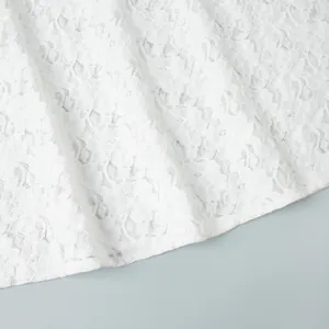 Nahaufnahme von weißem Blumen-Spitzenstoff mit feiner Stickerei und transparenter Textur