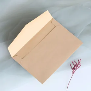 Close-up of brown kraft paper envelope with decorative purple dried flower and soft tulle