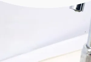 Primo piano di una spugna da cucina assorbente che crea una ricca schiuma insaponata
