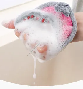 Dettaglio guanto spugna rosa e grigio che crea schiuma densa per una pulizia profonda