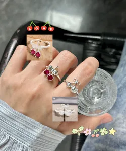 Detailed close-up of S925 silver cherry bow rings with red zircon gemstones on a hand