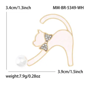 Broche chat en émail blanc avec nœud doré et grande perle sur fond blanc éclatant