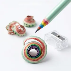 Close-up of rainbow paper pencil with multi-color lead and spiral shavings next to sharpener