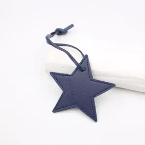 Detail of dark blue star-shaped PU leather pendant with lychee texture and stitching