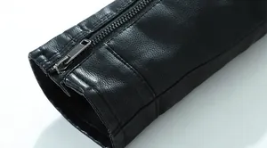 Nahaufnahme der Manschette einer schwarzen Lederjacke mit Kieselstruktur und Reißverschluss