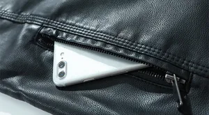 Detail der schwarzen Lederjacke mit Reißverschlusstasche und Smartphone-Größenvergleich