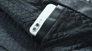 Detailansicht der gesteppten schwarzen Bikerjacke mit großer Tasche und einem Smartphone
