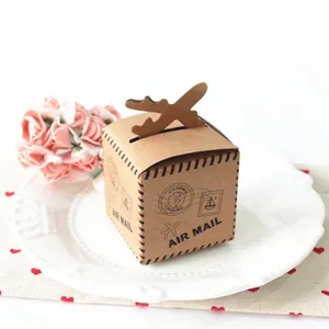 Vintage kraft paper candy box with air mail design and airplane handle on white lace plate
